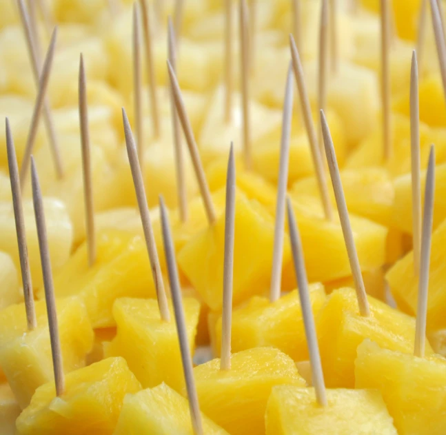 a pile of pineapple that has been cut into thin pins