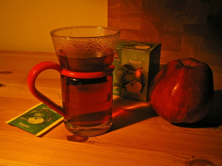 a drink and an apple sit on a table