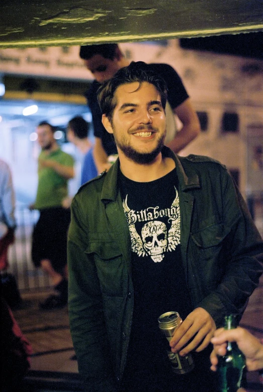 a man smiles while he holds a wine glass