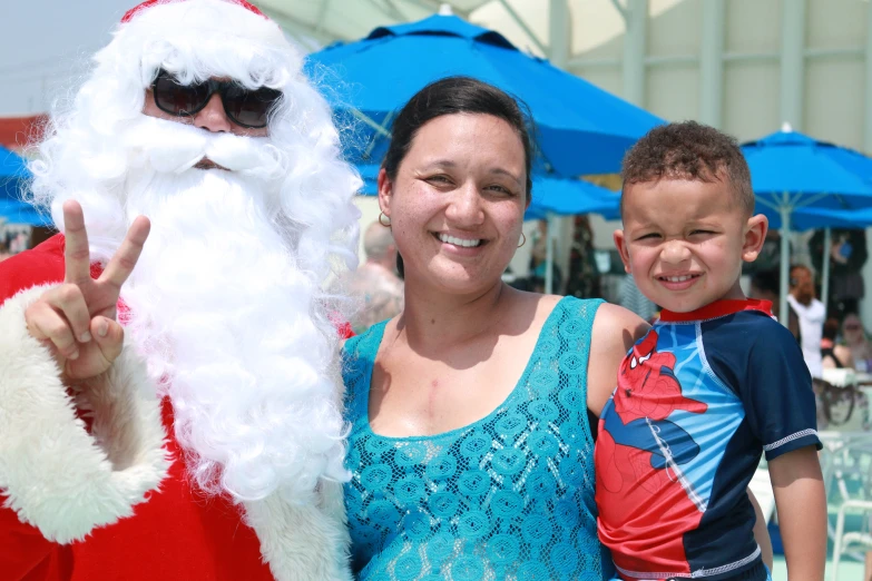 a lady and a boy pose for the camera while dressed up as santa