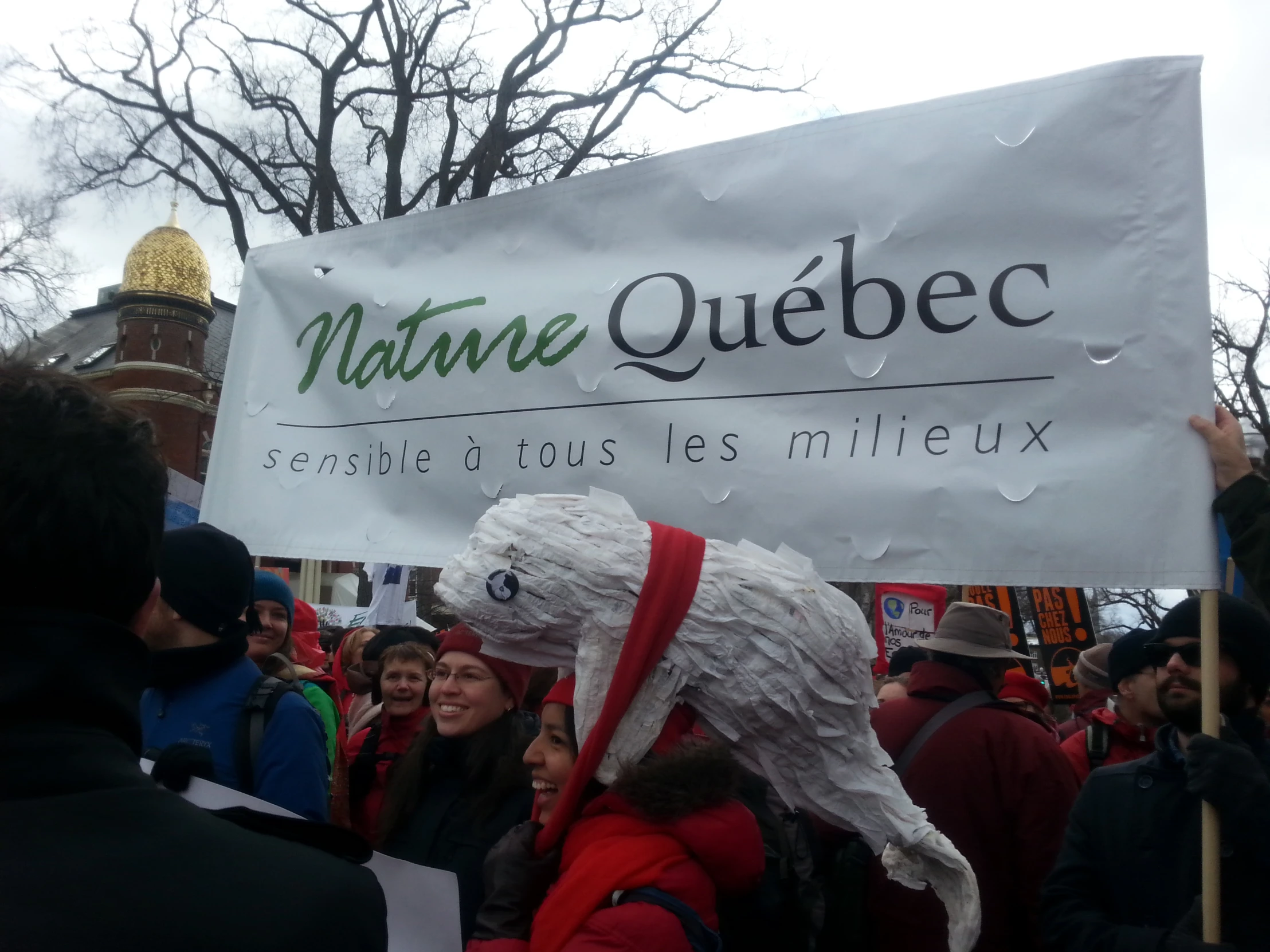 a large sign at a protest with some people holding signs