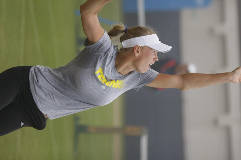 a woman with her tennis racquet on a grass court