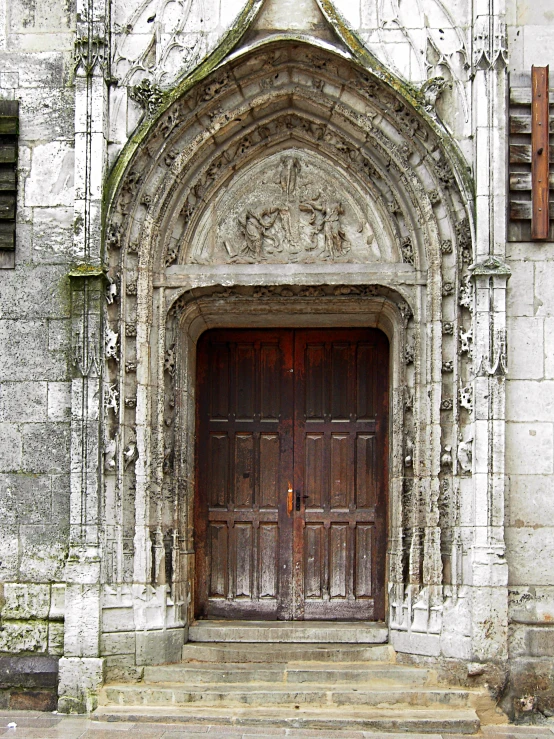 the doors are wood very old and have ornate ornaments on them