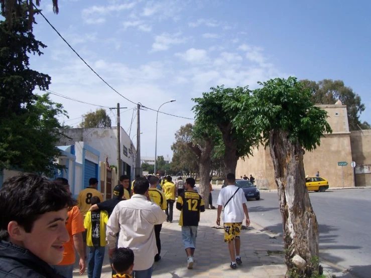 people walking along the street near parked cars