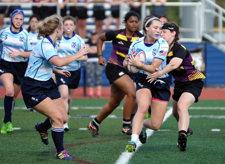 many girls are running through the grass while playing rugby