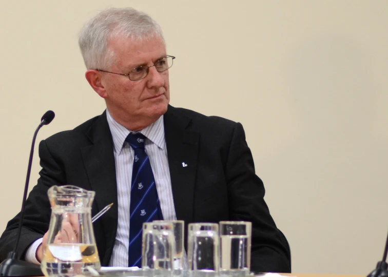 a man sitting at a table with three bottles of water