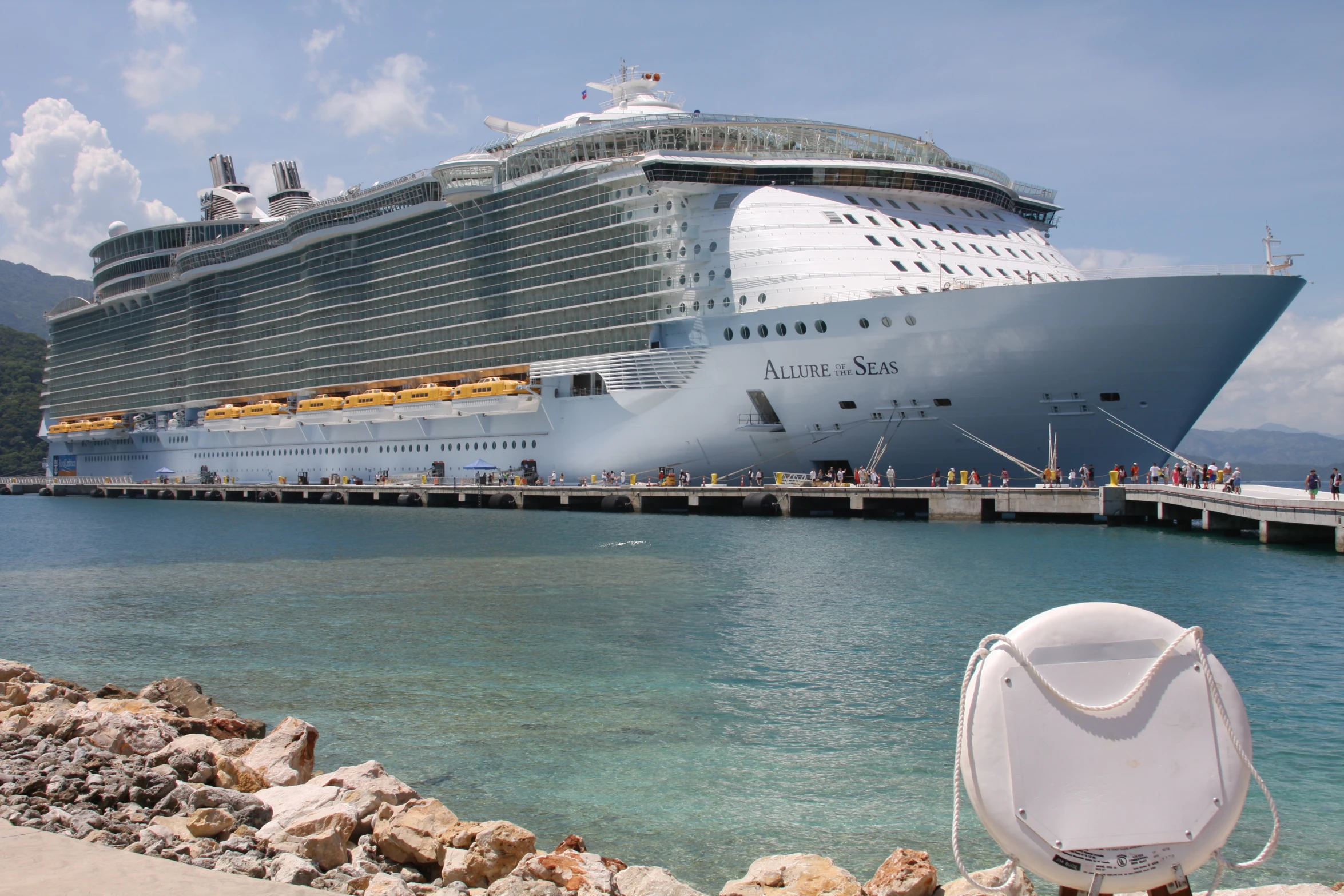 a cruise ship docked next to a pier on a sunny day