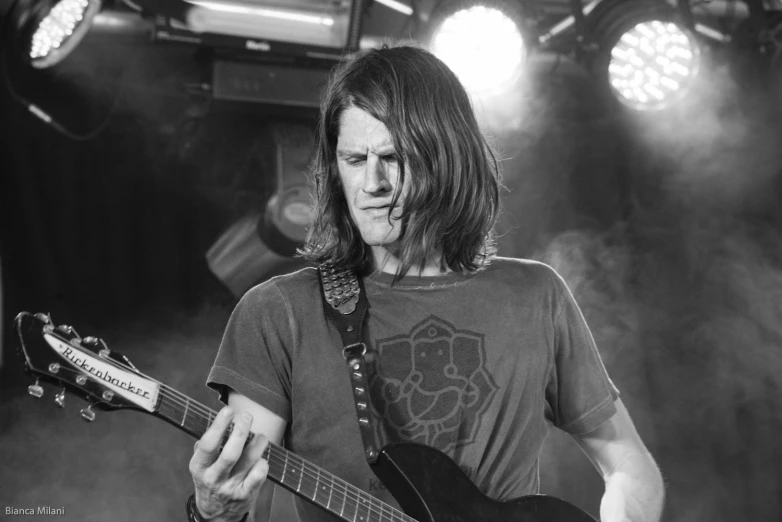 black and white pograph of a man playing an acoustic guitar