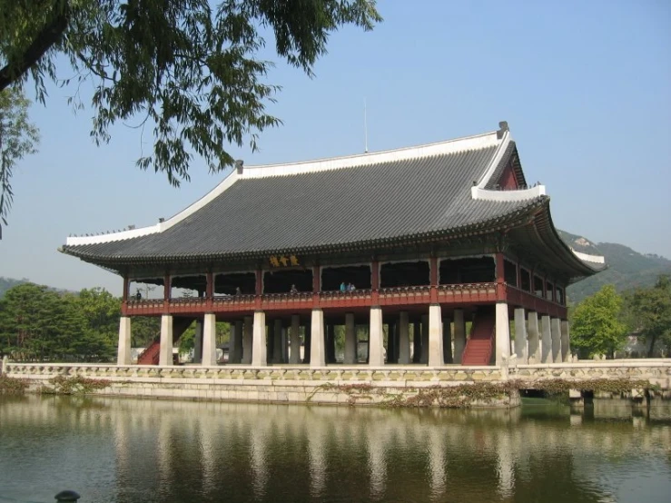 an asian building sitting next to the water