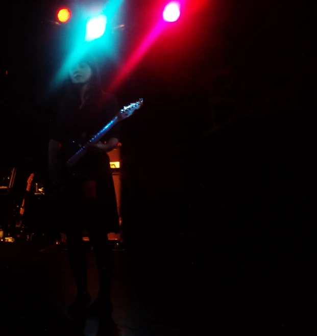 person holding a guitar with light shining from behind