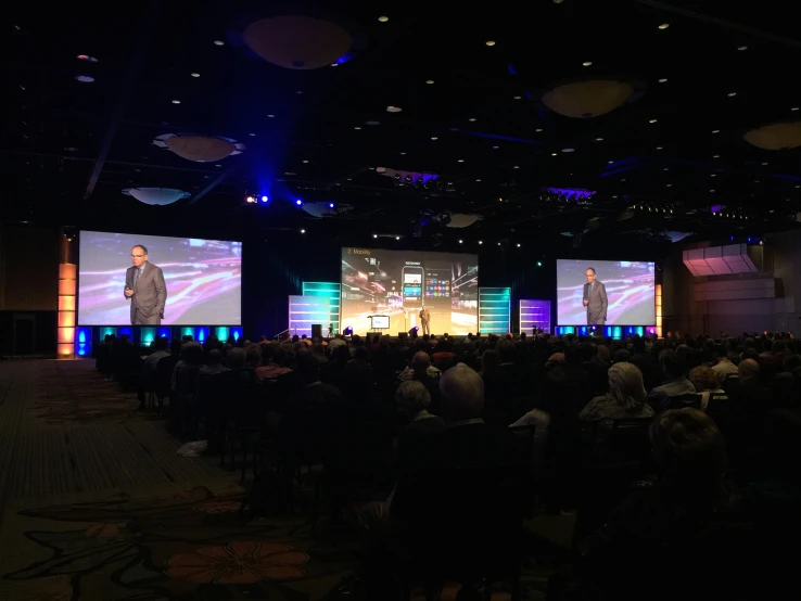 an audience in front of two large projection screens