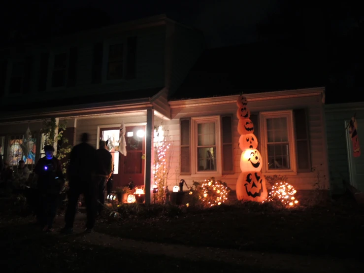 people standing outside a house decorated for halloween