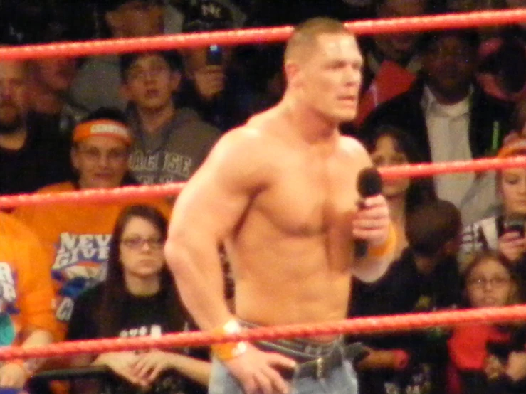 a male wrestler in the middle of a boxing ring