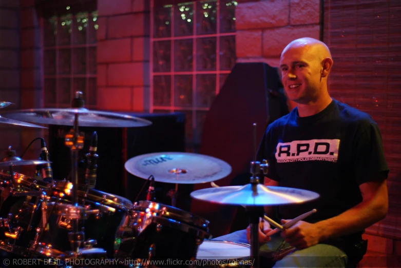 a man in an indoor recording studio playing drums