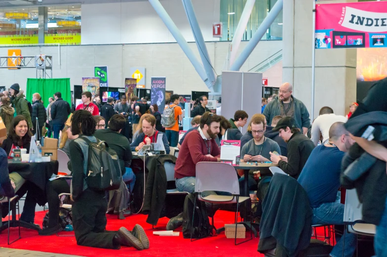 a crowd of people are gathered in a convention hall