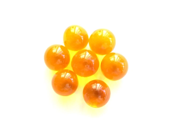 a group of orange glass beads on a white background