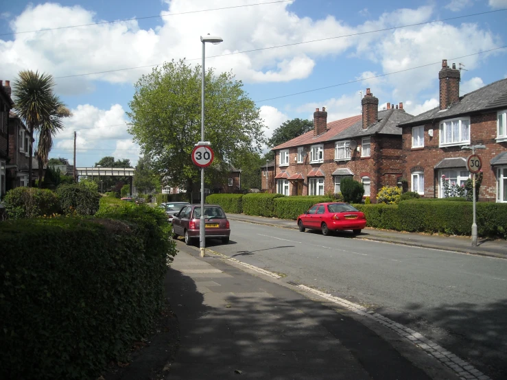 a row of houses with parked cars on a street