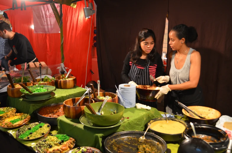 two women serving food to others at a buffet table