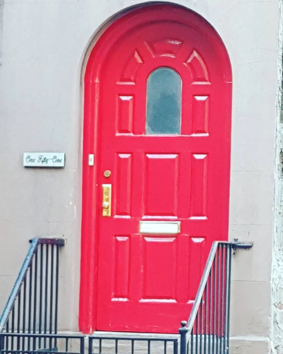 a red door on the side of a building with iron gates