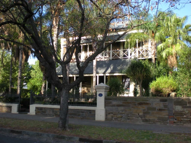 a large house on the street in front of a fence