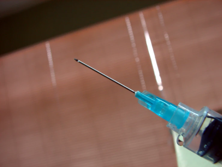 a needle inserted in to a container that is placed on a table