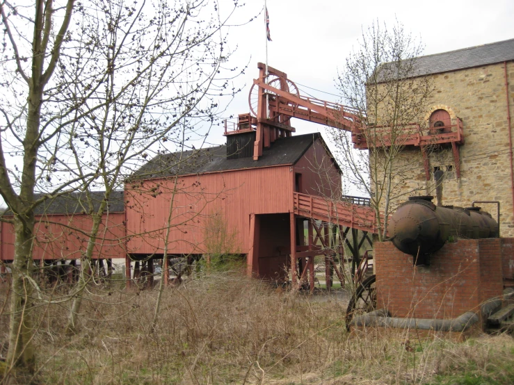 an old factory with a tower is shown in the middle of a field