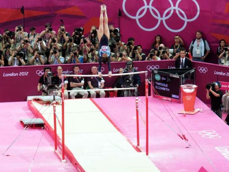 a woman is on a balance beam during an event