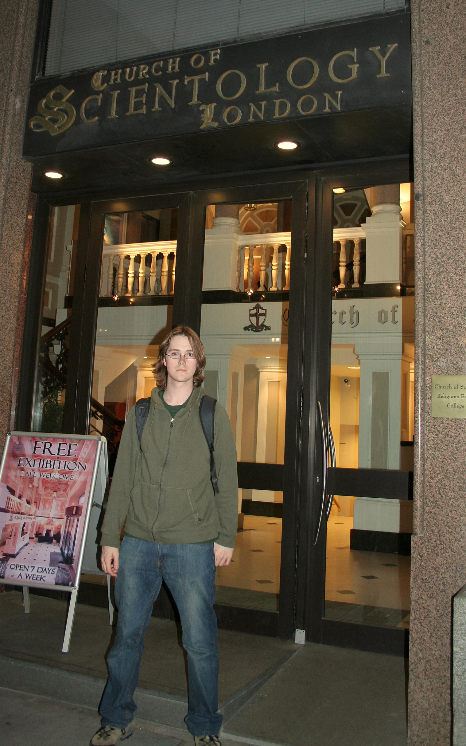 a man posing outside of a building at night