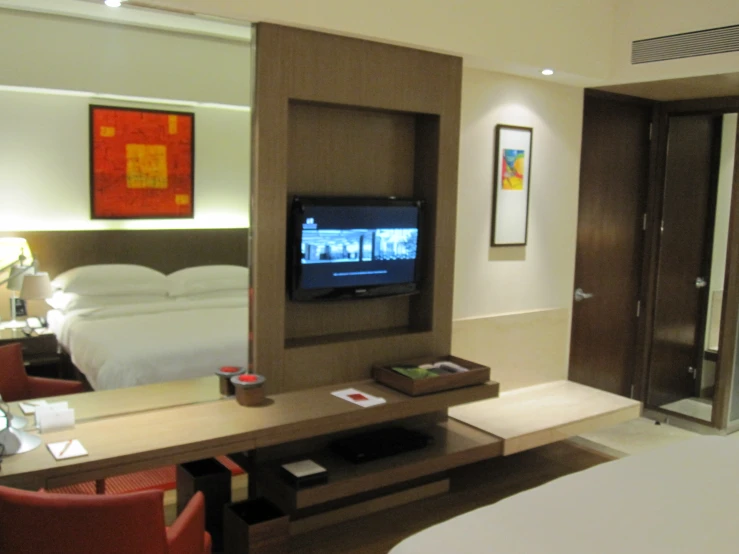 a el room with a tv, vanity and bed