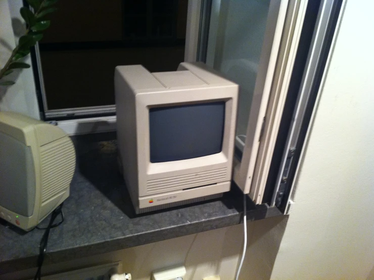 an old macintosh computer next to other electronic appliances