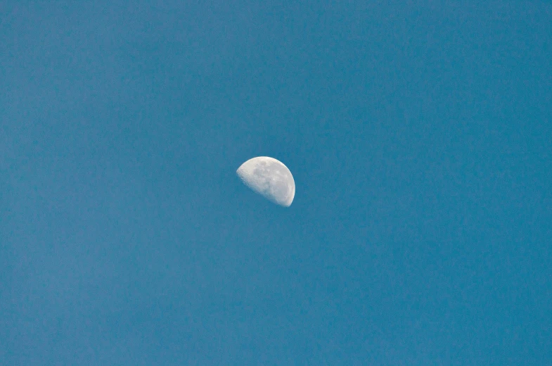 the moon is visible in the clear blue sky, an album cover, unsplash, postminimalism, ignant, hazy, 2000s photo, telephoto