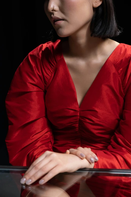 a woman in a red dress sitting at a table, an album cover, inspired by Esaias Boursse, trending on pexels, renaissance, tight wrinkled cloath, detail shot, nanae kawahara, puff sleeves