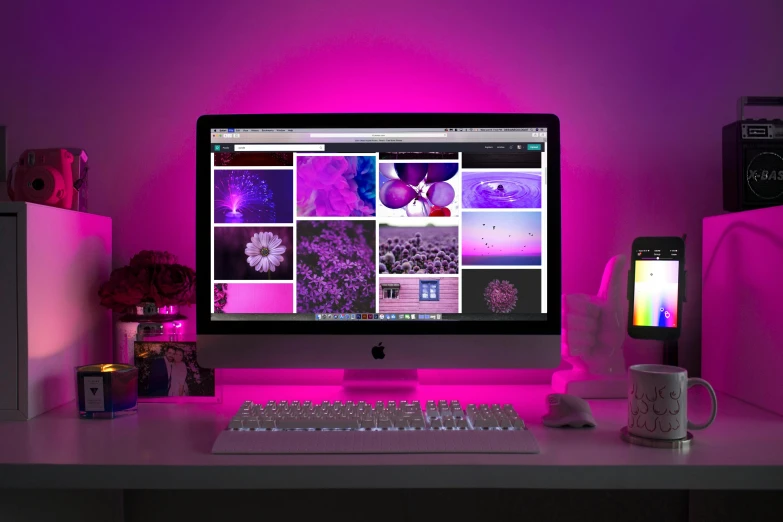 a desktop computer sitting on top of a white desk, inspired by Elsa Bleda, trending on pexels, computer art, bright pink purple lights, many screens, soft coloured gel lighting, rgb wall light
