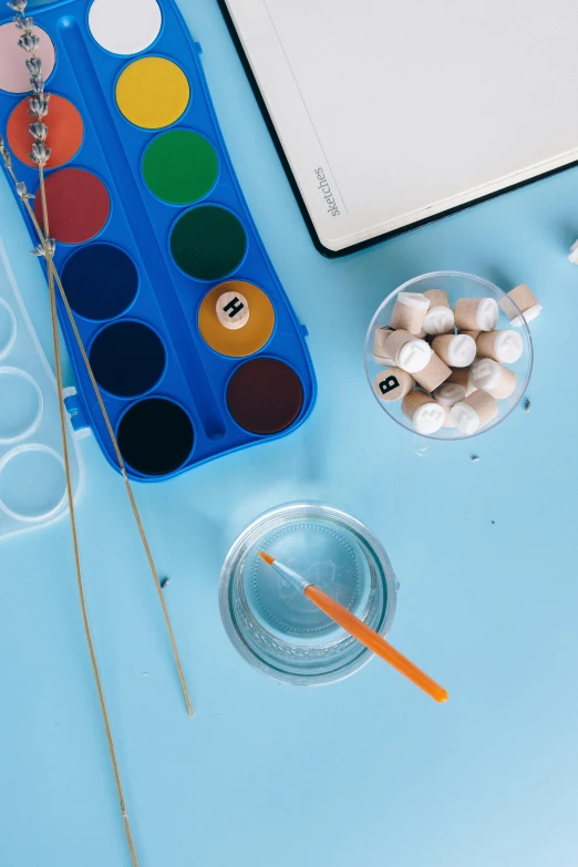 a laptop computer sitting on top of a blue table, a child's drawing, inspired by Damien Hirst, trending on pexels, test tubes, white paint, floating objects, medium close up shot