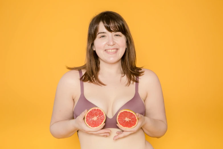 a woman in a bikini holding two grapefruits, pexels contest winner, andy milonakis, wearing bra, h3h3, portait image