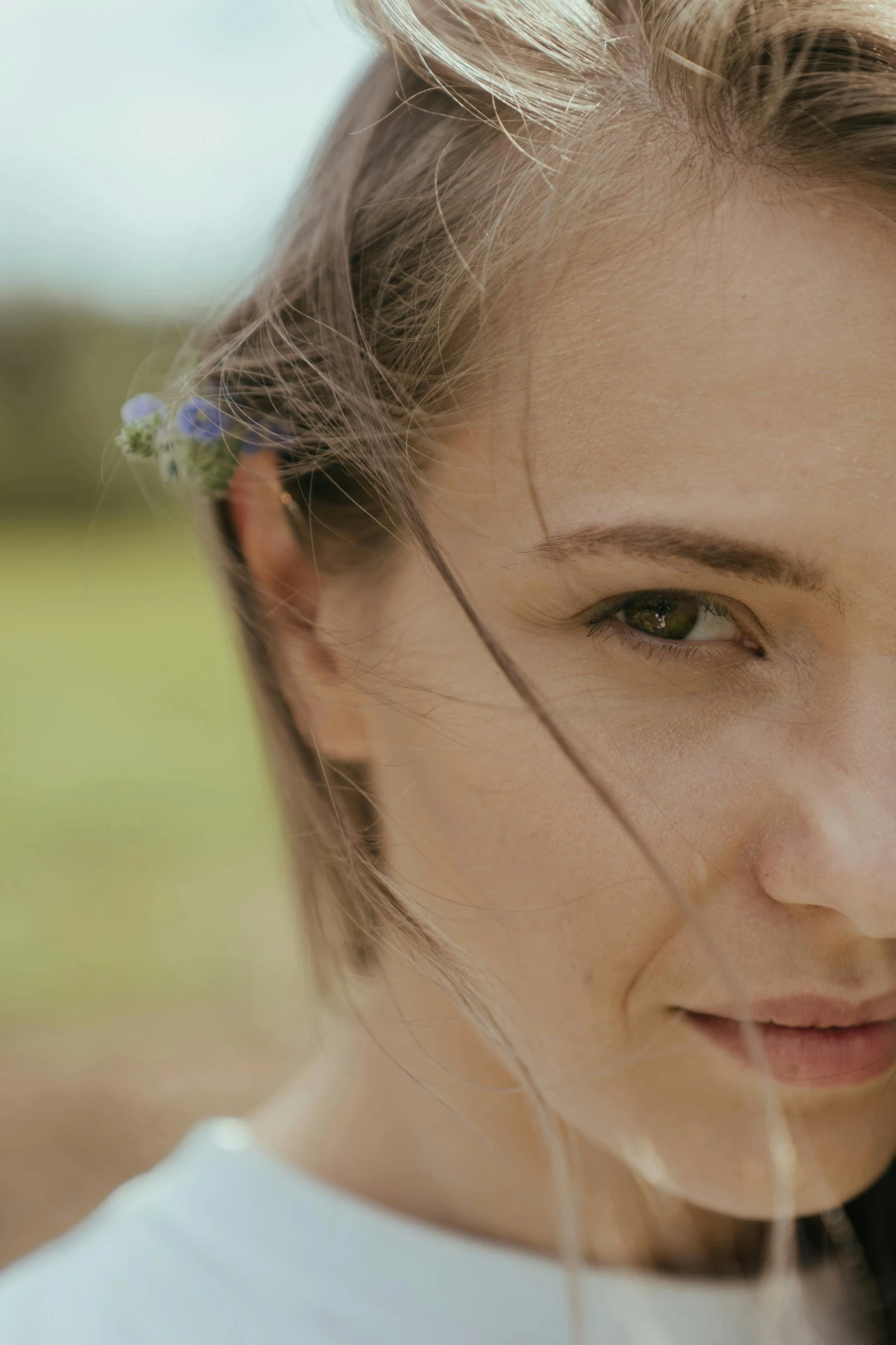 a woman with a flower in her hair, unsplash, slight stubble, rugged face, young southern woman, close angle