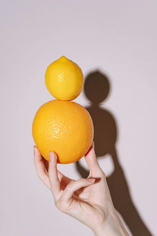 a person holding two oranges in their hands, inspired by Ren Hang, trending on pexels, with lemon skin texture, large tall, single light, perfectly shaded body