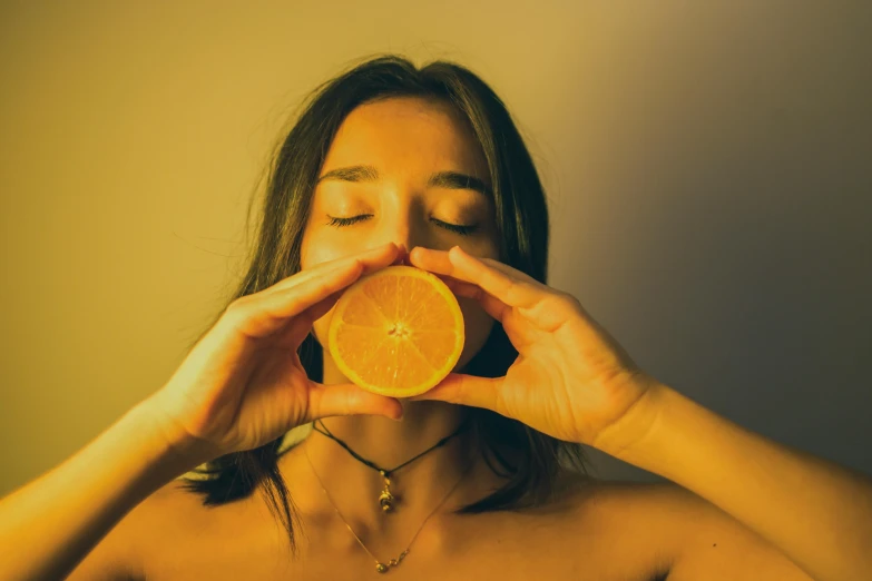 a woman holding an orange in front of her face, pexels contest winner, lemonlight, avatar image, body shot, profile image