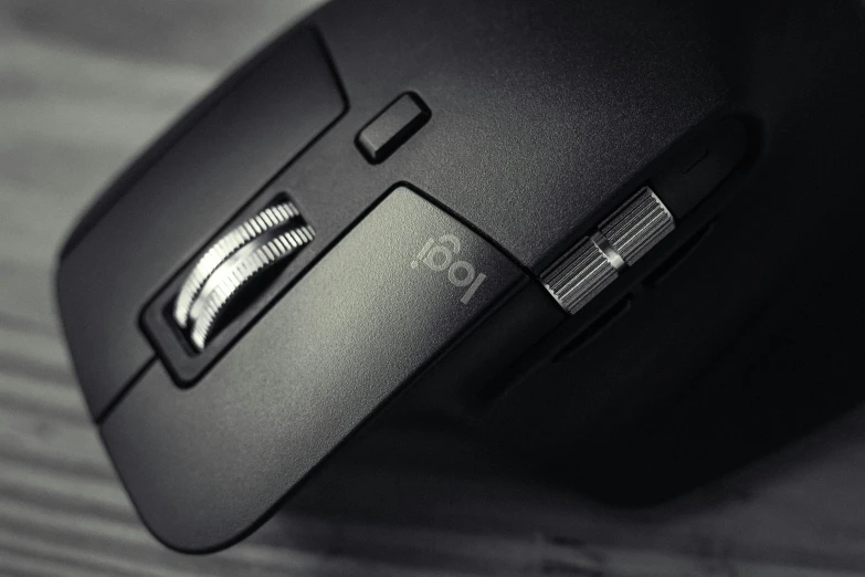 a close up of a computer mouse on a table, shot on canon eos r 5, all black matte product, detailed shot legs-up, visible stitching