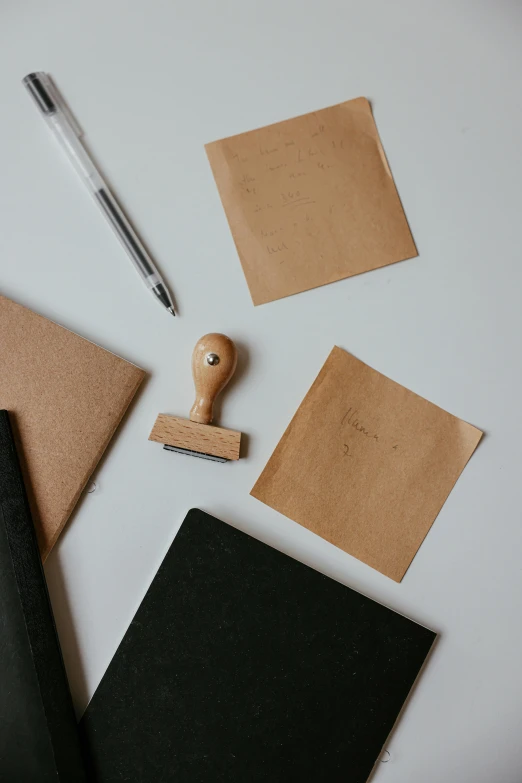 a wooden stamper sitting on top of a piece of paper, trending on unsplash, private press, square shapes, leather, pen on white paper, thumbnail