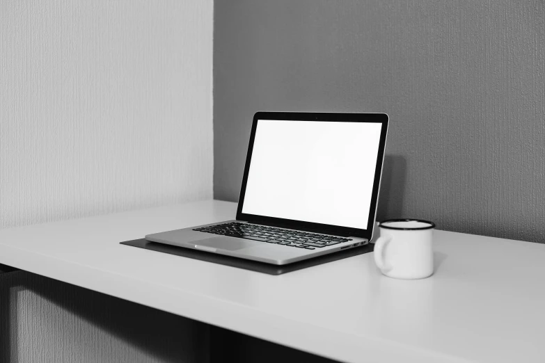 a laptop computer sitting on top of a white desk, black + white, black white