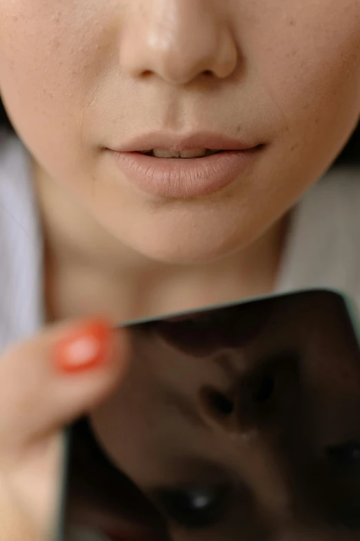 a close up of a person holding a cell phone, a picture, lips slightly parted, square face, flesh with technology, youthful face