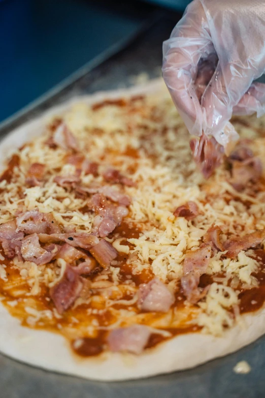 a person putting cheese on top of a pizza, pork, slide show, uncropped, thumbnail