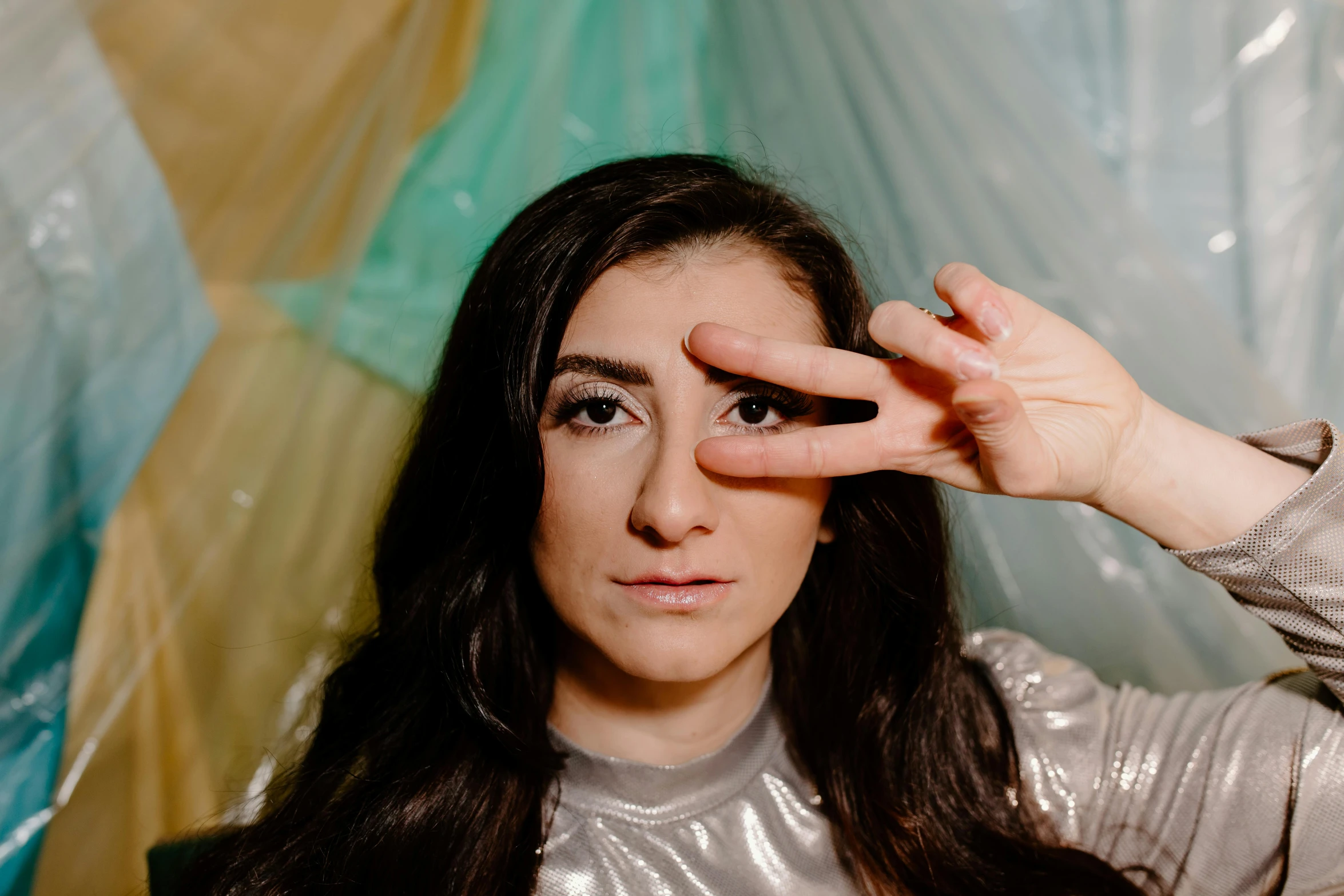 a woman holding up a pair of scissors to her eye, an album cover, by Julia Pishtar, trending on pexels, antipodeans, betty la fea, wave a hand at the camera, yael shelbia, portrait image