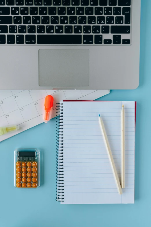 a laptop computer sitting on top of a desk next to a calculator, trending on pexels, academic art, snacks, with a blue background, lined paper, medical supplies