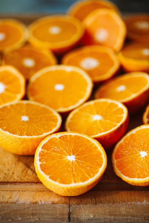 a wooden cutting board topped with sliced oranges, zoomed in, slide show, laura watson, up close