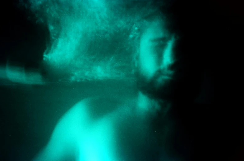 a close up of a person in a body of water, an album cover, inspired by Elsa Bleda, phosphorescent, 30 year old man, in a claustrophobic, photo taken on fujifilm superia