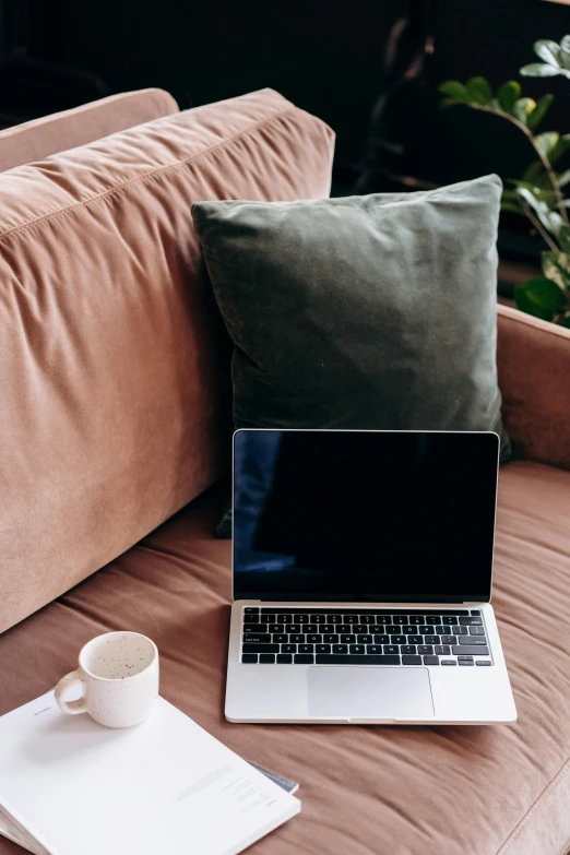 a laptop computer sitting on top of a couch next to a cup of coffee, velvet couch, connectivity, rectangle, gold