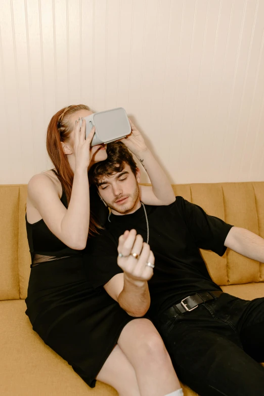 a man and a woman sitting on a couch, an album cover, trending on pexels, virtual reality headset, discord profile picture, playful pose, ethan klein