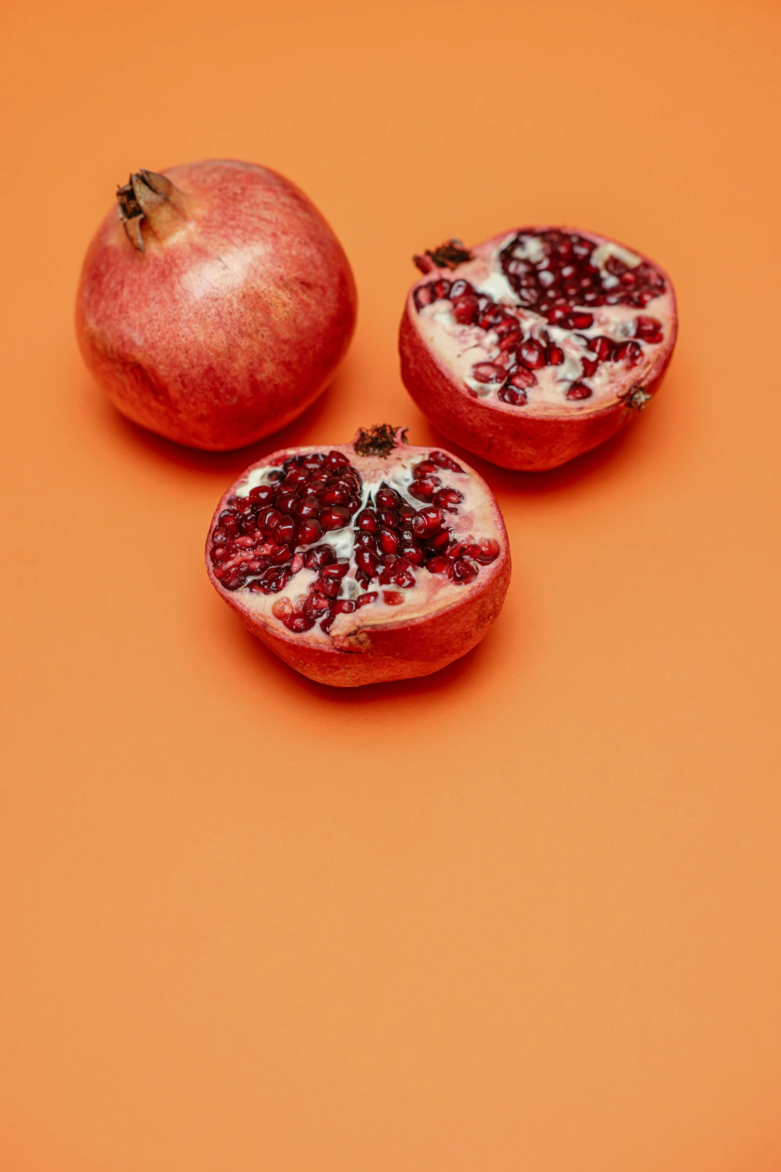 three pomegranates on an orange background, trending on pexels, half - body shot, persian queen, medium - shot, grape